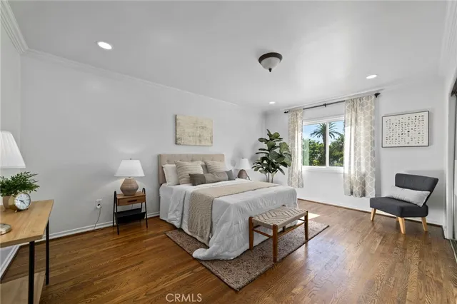 a bedroom with a large bed and a potted plant