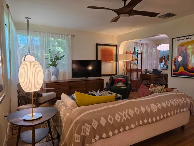 a living room with furniture a lamp and a flat screen tv