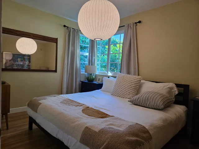 a bedroom with a bed and a painting on the wall