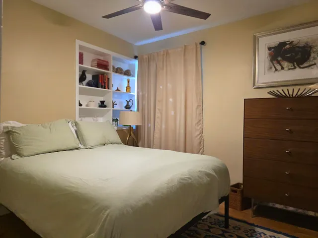 a large bed in a bedroom next to a cabinet
