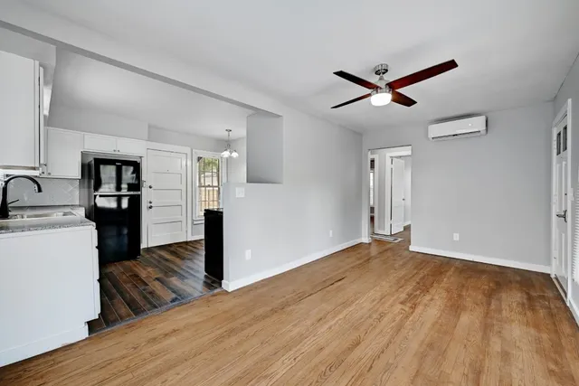 a view of empty room with wooden floor and ceiling fan
