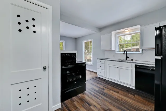 a kitchen with granite countertop a refrigerator and a sink