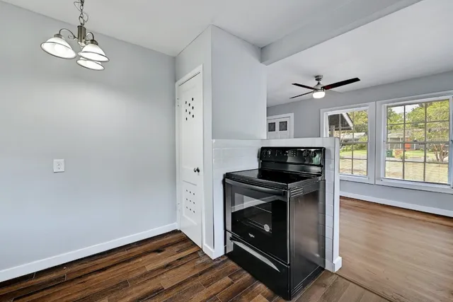 a kitchen with wooden floor and stainless steel appliances