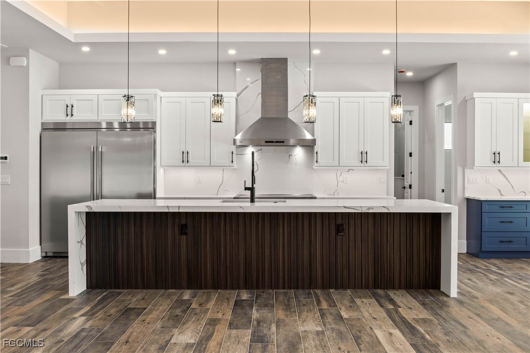 3906 Southwest 6th Terrace Cape Coral, FL 33991 - Photo 16 of 50 a kitchen with stainless steel appliances granite countertop a refrigerator a sink and wooden cabinets