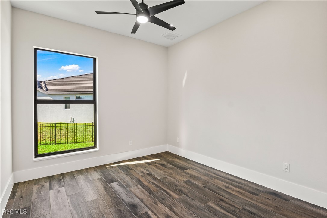 3906 Southwest 6th Terrace Cape Coral, FL 33991 - Photo 30 of 50 an empty room with wooden floor closet and windows