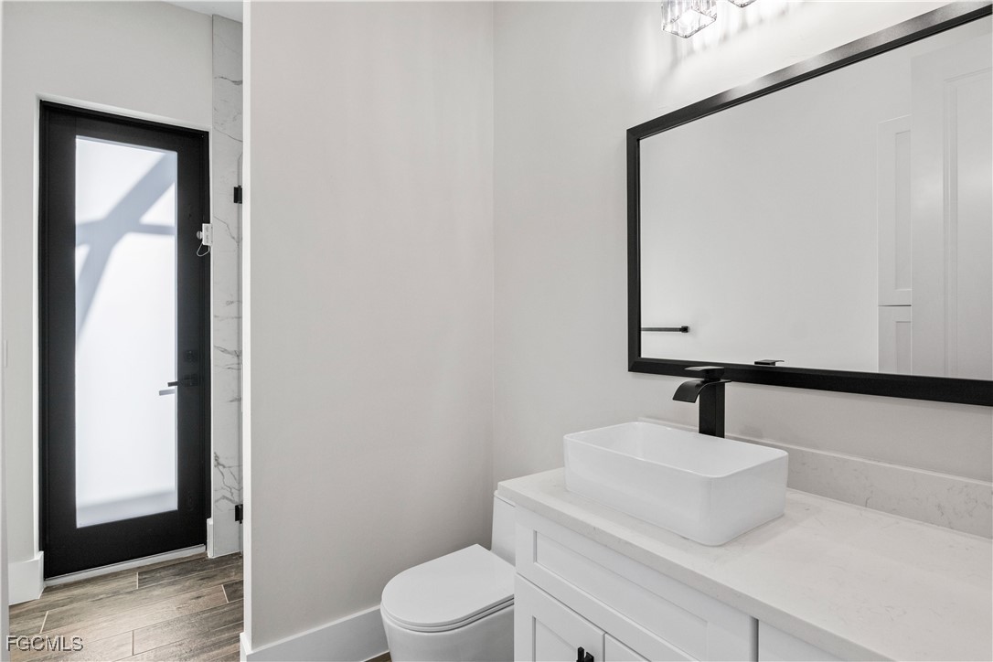 3906 Southwest 6th Terrace Cape Coral, FL 33991 - Photo 35 of 50 a bathroom with a sink a toilet and mirror