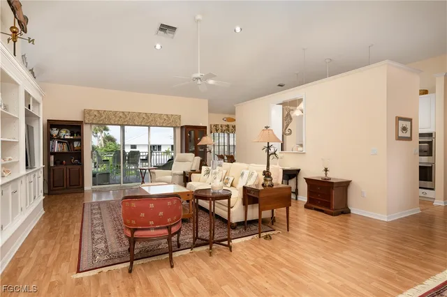 a living room with furniture a flat screen tv and kitchen view