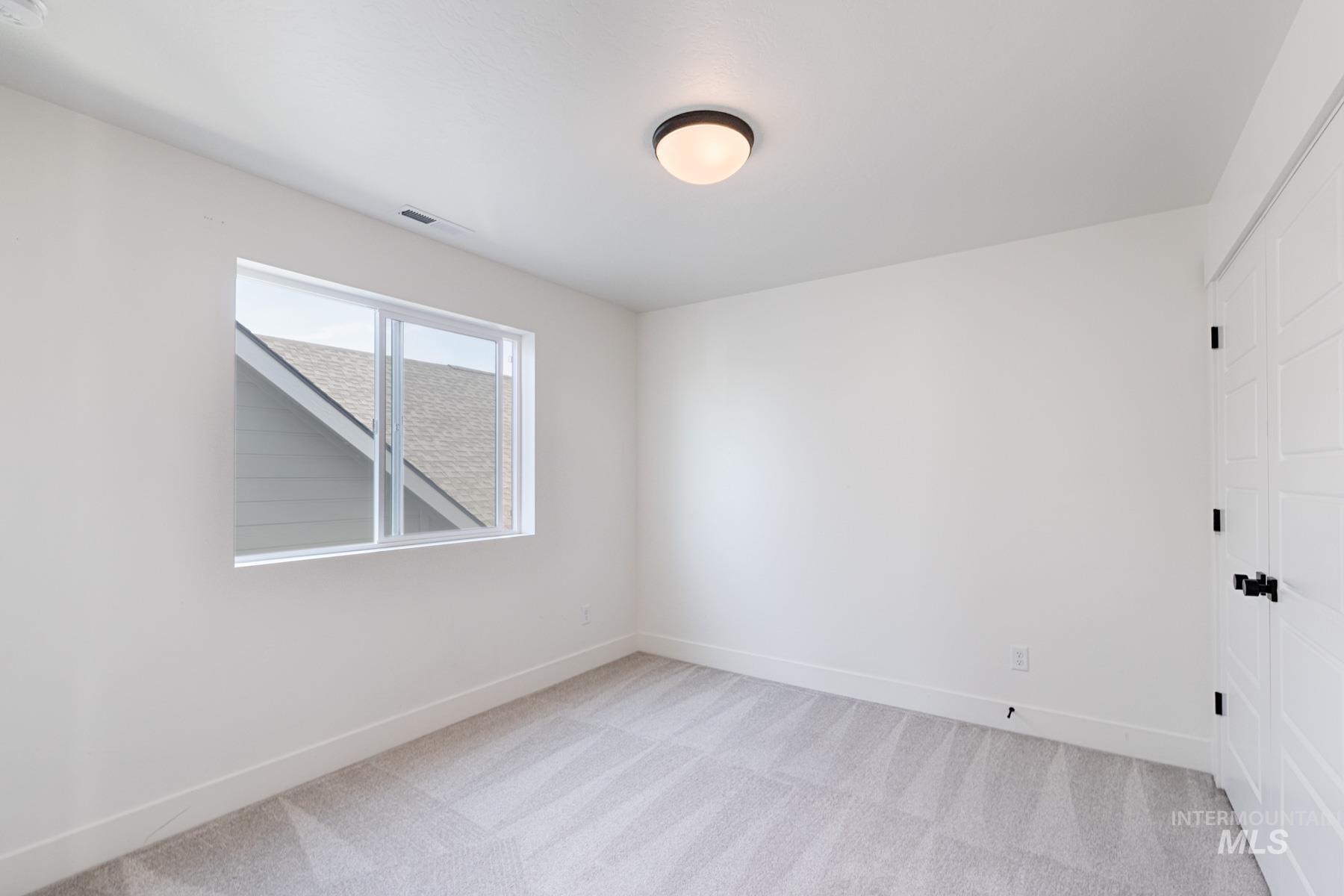 6216 South Wayland Way Meridian, ID 83642 - Photo 27 of 38 Bright room featuring white walls, a single-pane window, flush-mount ceiling light, and light-toned patterned carpeting