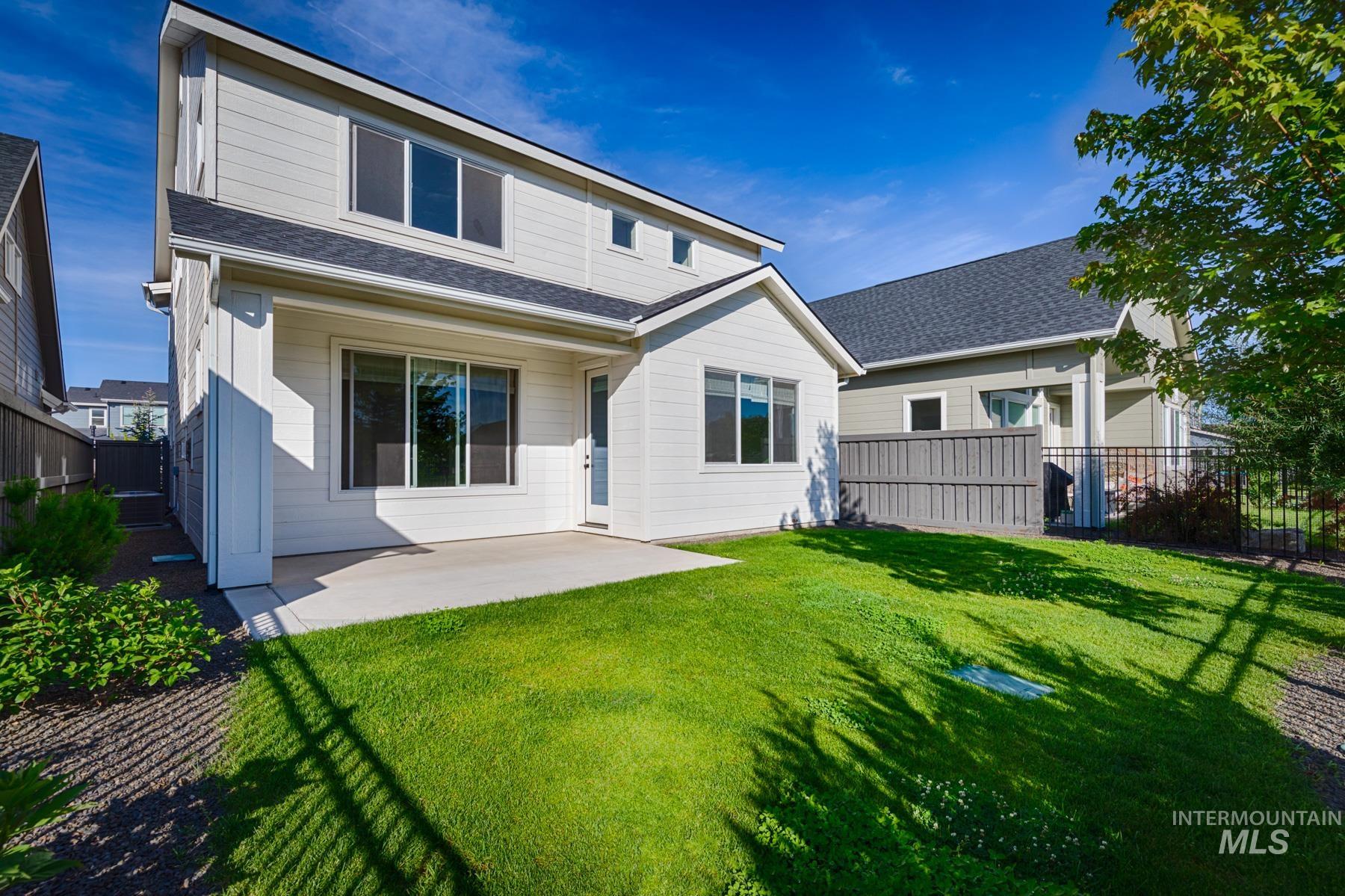 6216 South Wayland Way Meridian, ID 83642 - Photo 33 of 38 Rear exterior featuring a concrete patio, expansive lawn, and architectural siding