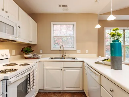 a kitchen with white cabinets and white appliances