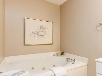 a bathroom with a bathtub and a picture on the wall