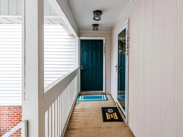 a view of a hallway with wooden floor and windows