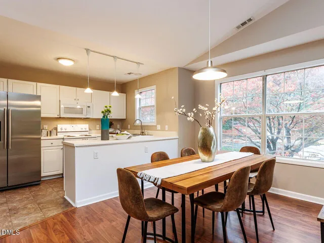 a dining room filled chandelier and wooden floor
