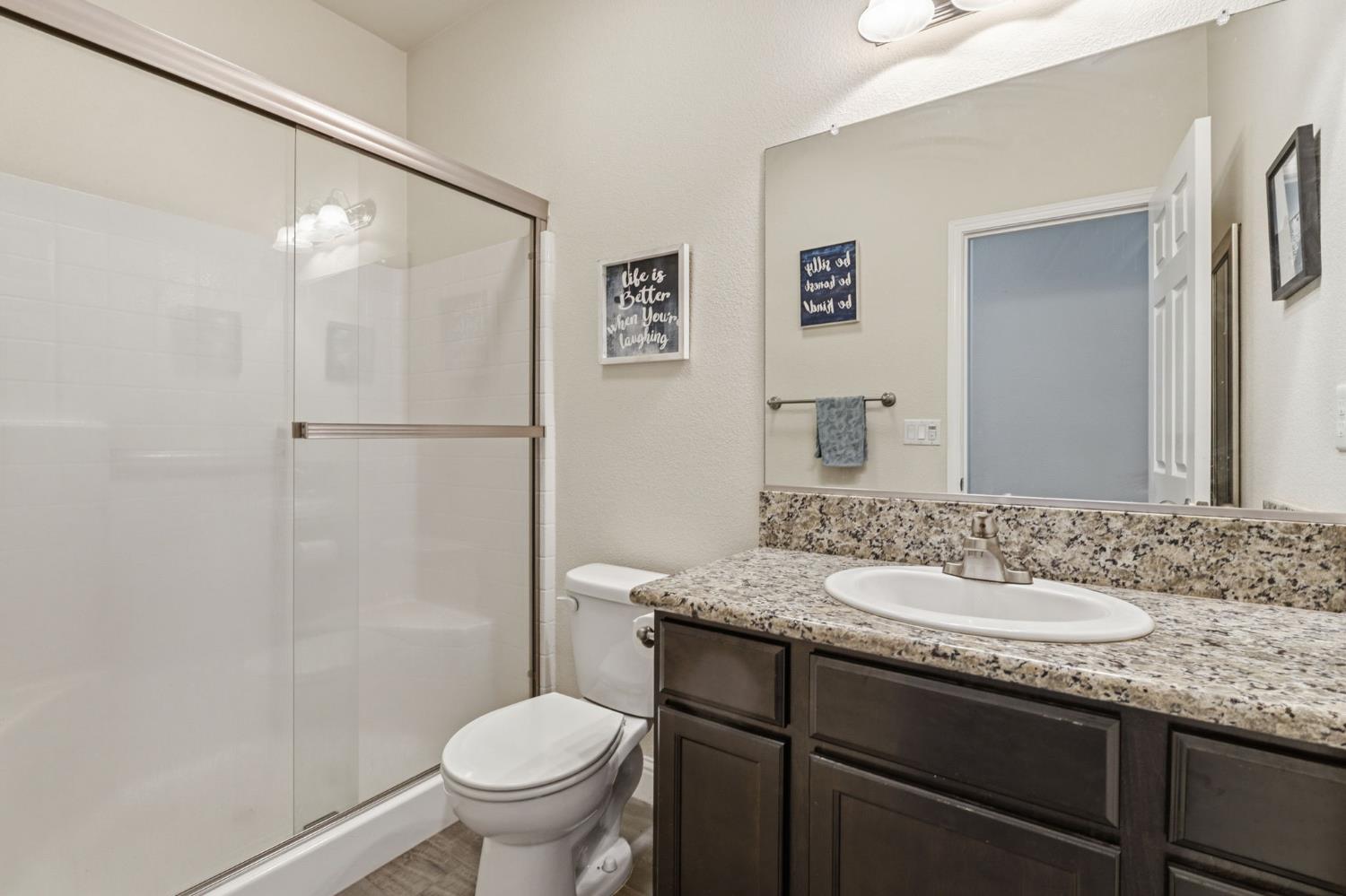 15717 West Botelho Avenue Kerman, CA 93630 - Photo 11 of 43 a bathroom with a granite countertop sink toilet and shower