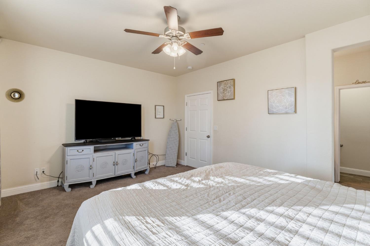 15717 West Botelho Avenue Kerman, CA 93630 - Photo 15 of 43 a bedroom with a bed and a flat screen tv