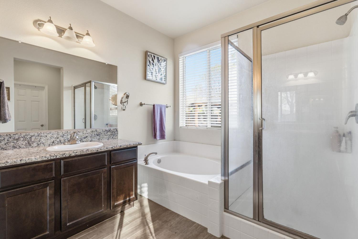 15717 West Botelho Avenue Kerman, CA 93630 - Photo 16 of 43 a bathroom with a granite countertop sink a bathtub and shower