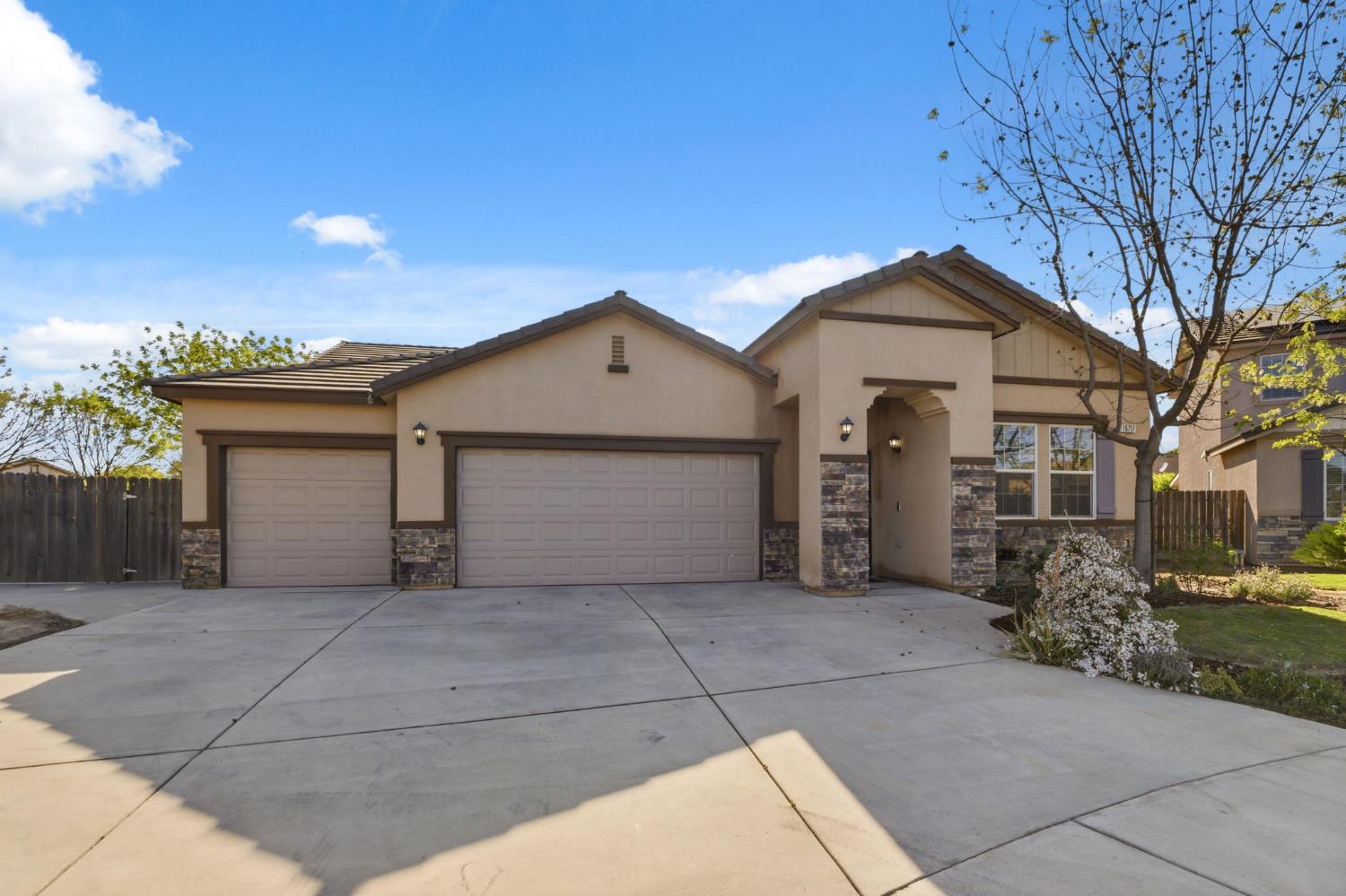 15717 West Botelho Avenue Kerman, CA 93630 - Photo 4 of 43 a view of a house with a yard and garage