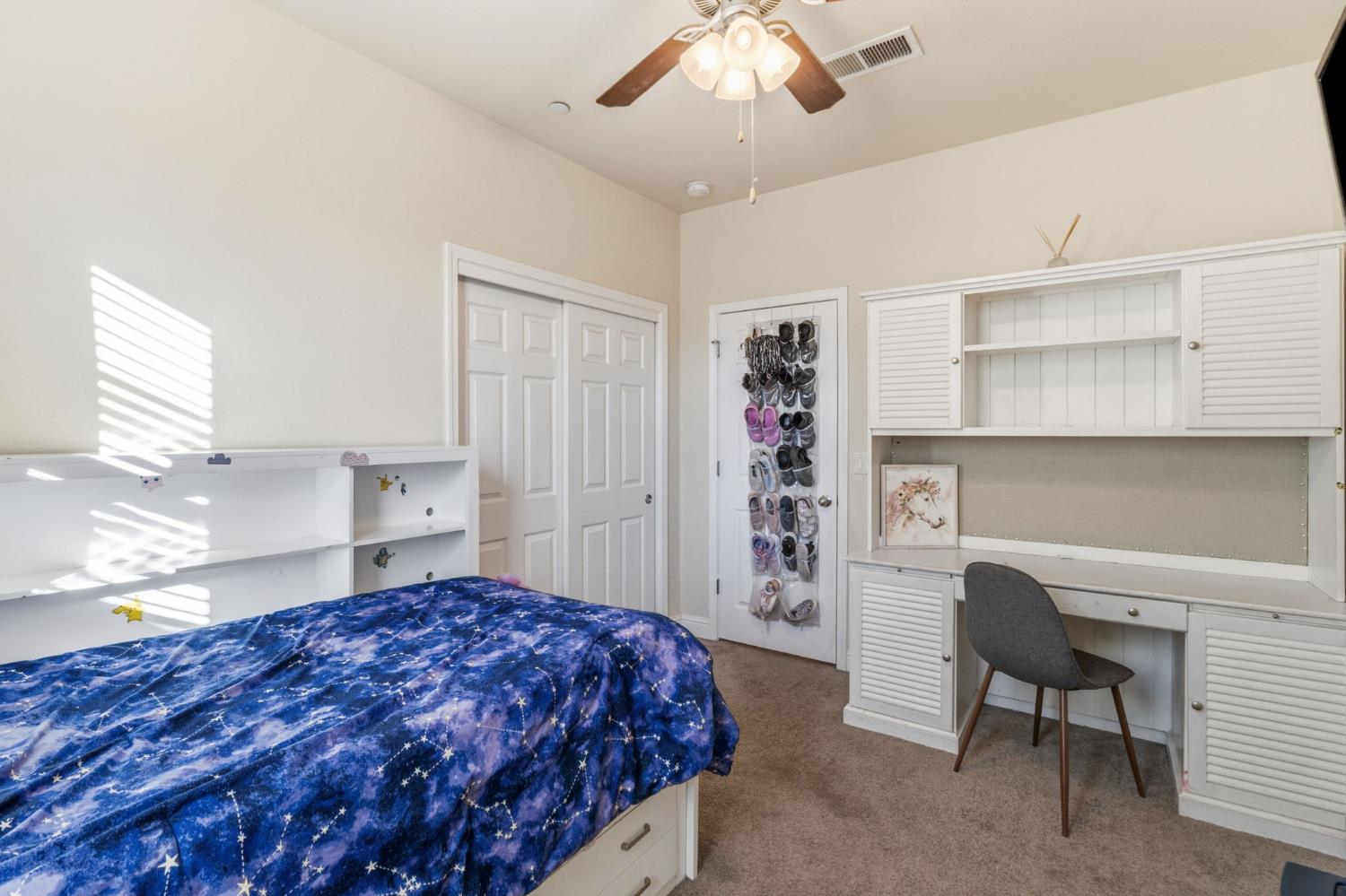 15717 West Botelho Avenue Kerman, CA 93630 - Photo 10 of 43 a bedroom with a bed and a chandelier