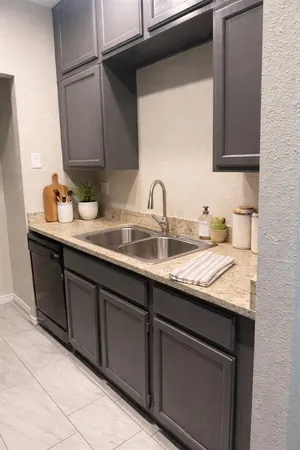 a kitchen with granite countertop a sink and cabinets