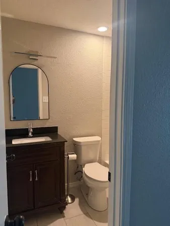 a bathroom with a toilet sink vanity and mirror