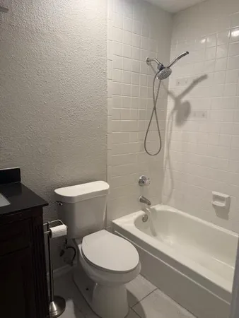a bathroom with a granite countertop toilet a sink and a shower