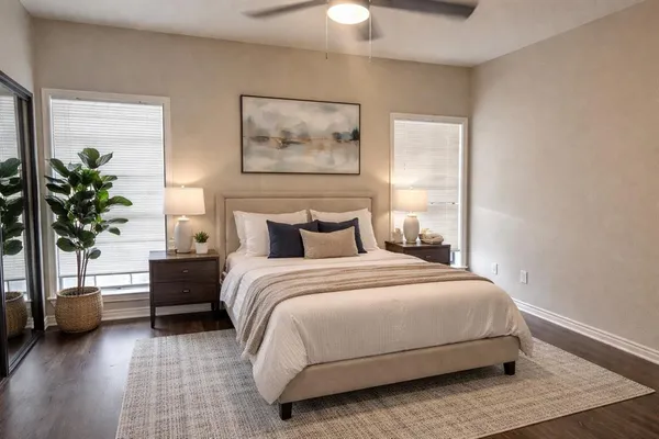 a bedroom with a bed lamp and a potted plant