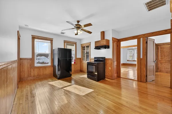 a living room with stainless steel appliances furniture and a kitchen view