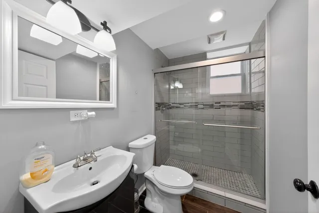 a bathroom with a sink mirror toilet and shower