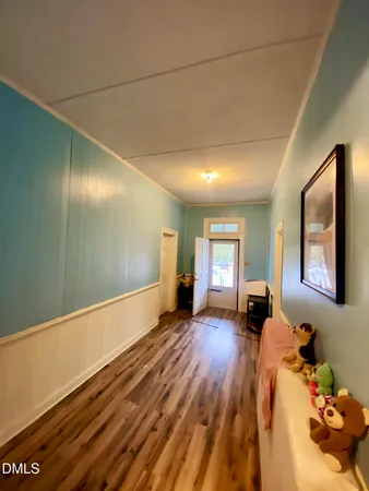 a spacious bedroom with a bed and wooden floor