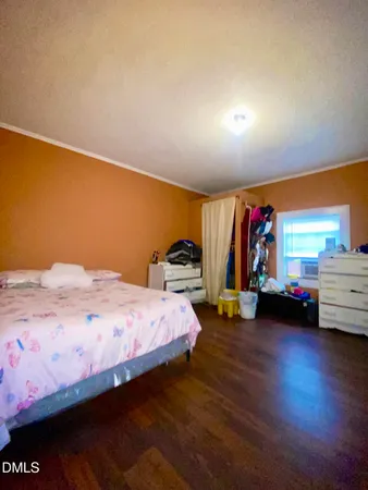 a bedroom with bed and wooden floor
