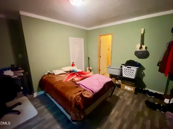 a bedroom with a bed and wooden floor