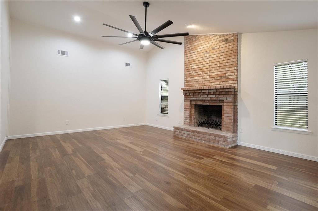 100 East Cunningham Street Bonham, TX 75418 - Photo 11 of 35 an empty room with wooden floor fireplace and windows