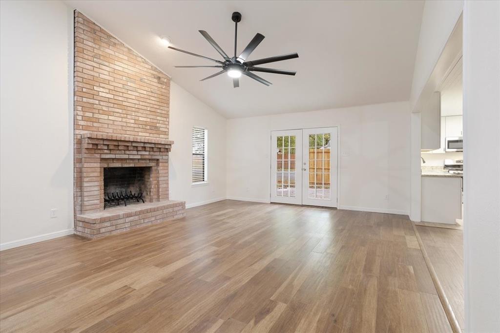 100 East Cunningham Street Bonham, TX 75418 - Photo 12 of 35 an empty room with wooden floor fireplace and windows