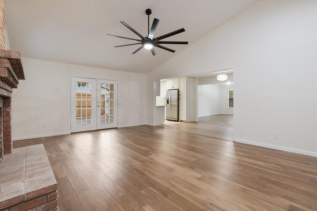 100 East Cunningham Street Bonham, TX 75418 - Photo 13 of 35 an empty room with wooden floor chandelier fan and windows