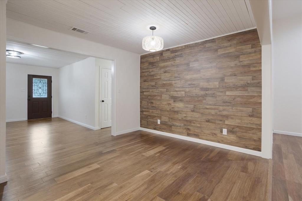 100 East Cunningham Street Bonham, TX 75418 - Photo 15 of 35 wooden floor in an empty room with a window