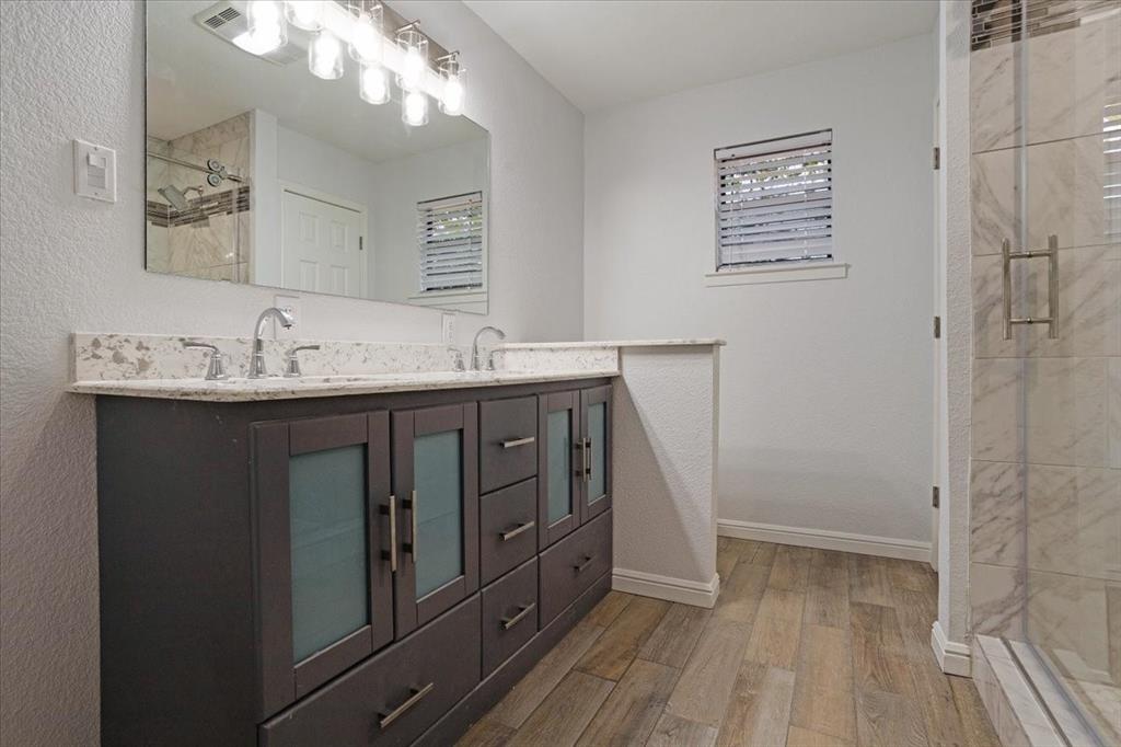 100 East Cunningham Street Bonham, TX 75418 - Photo 25 of 35 a bathroom with a sink a mirror and a shower