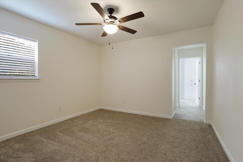 100 East Cunningham Street Bonham, TX 75418 - Photo 28 of 35 an empty room with a chandelier fan and windows