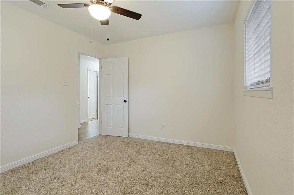 100 East Cunningham Street Bonham, TX 75418 - Photo 33 of 35 an empty room with a ceiling fan and a window