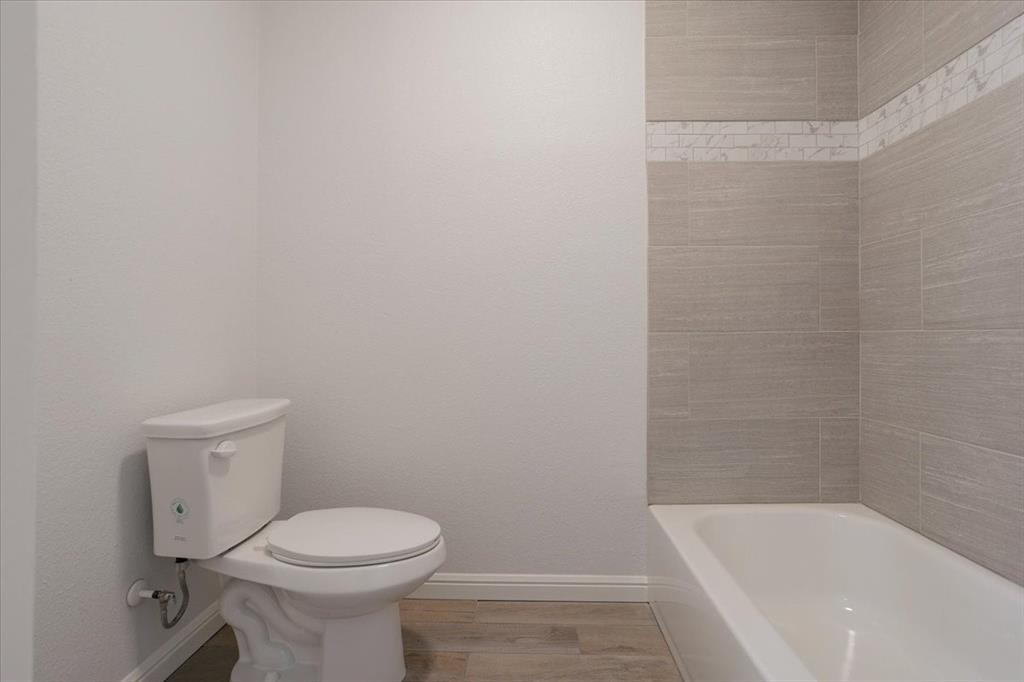 100 East Cunningham Street Bonham, TX 75418 - Photo 35 of 35 a white toilet sitting next to a bath tub