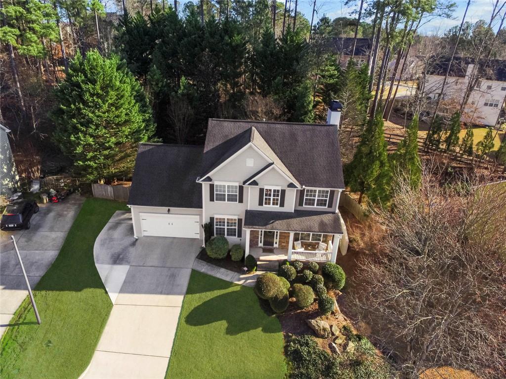 an aerial view of a house with a yard and large trees