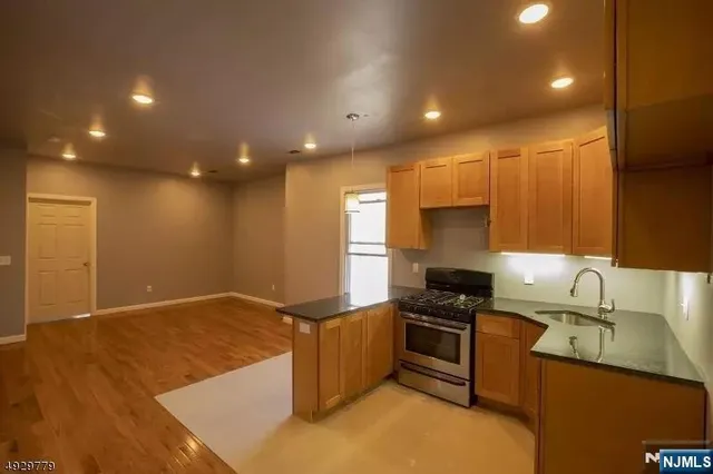 a kitchen with kitchen island sink stove and cabinets
