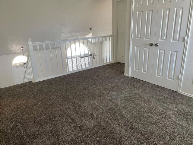a view of staircase with railing and white walls
