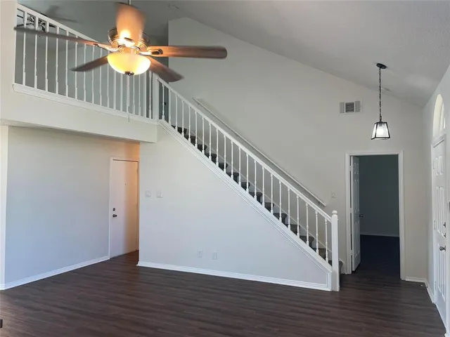 a view of a hallway with wooden floor and stairs
