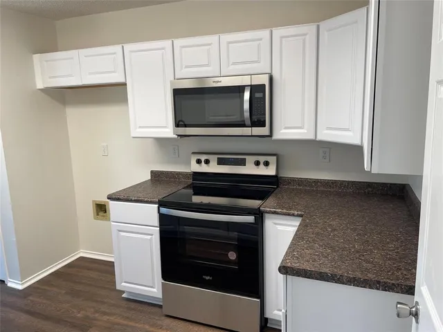 a kitchen with stainless steel appliances granite countertop a stove microwave and sink
