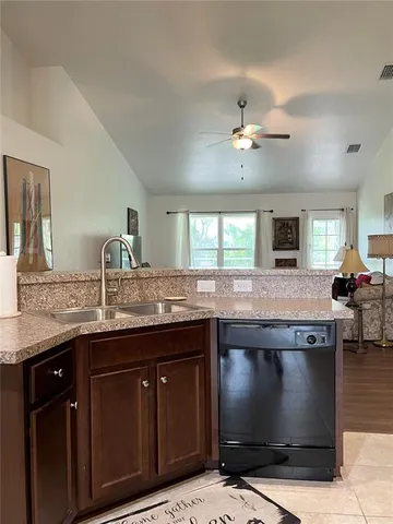 a open kitchen with stainless steel appliances kitchen island granite countertop a refrigerator and a stove top oven with wooden floor