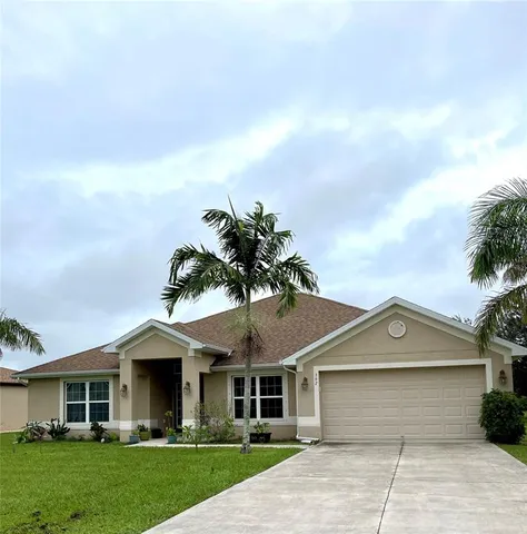 a front view of a house with a garden and yard