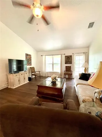 a living room with furniture a dining table and a potted plant