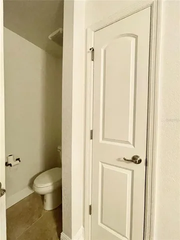 a view of a bedroom with a bed and wooden floor