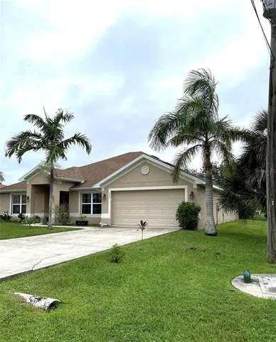 a view of a big yard with plants and large trees