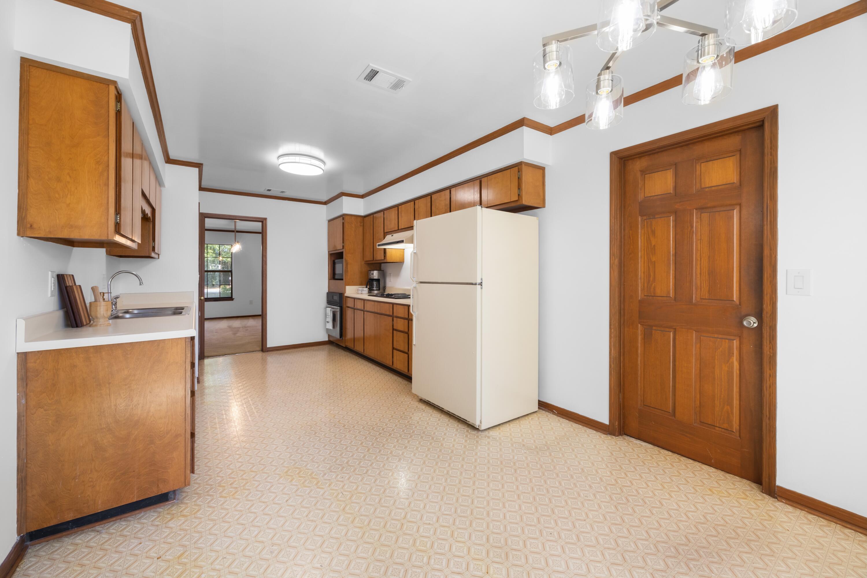3066 Craig Terrace Crestview, FL 32539 - Photo 13 of 43 a kitchen with refrigerator and cabinets